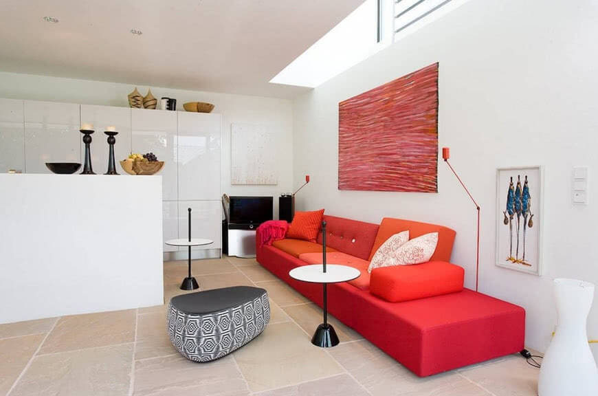 Белая гостиная красный диван серый пуф аксессуары