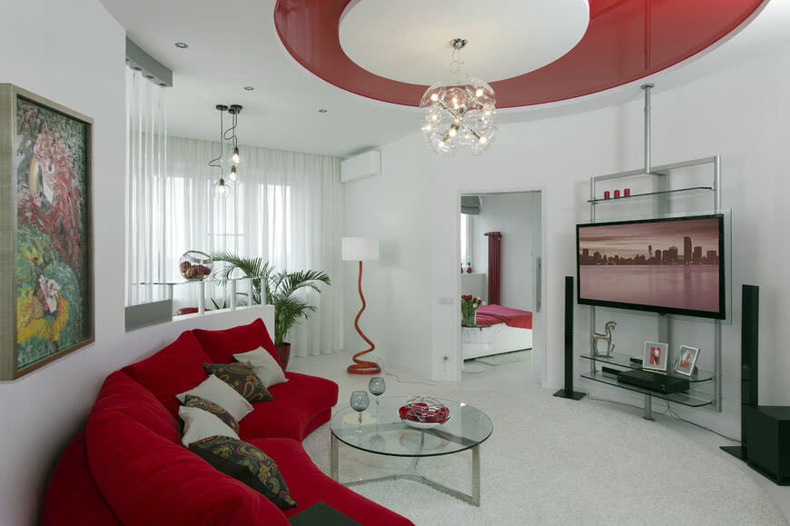Гостиная светлые стены красный диван потолок столик из стекла