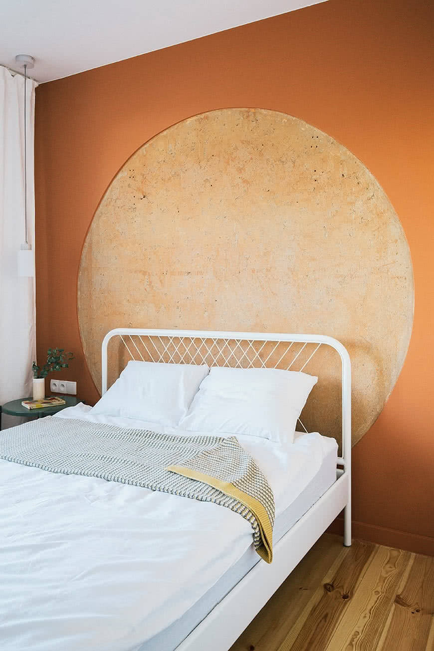 Светлая спальня белая кровать оранжевая стена