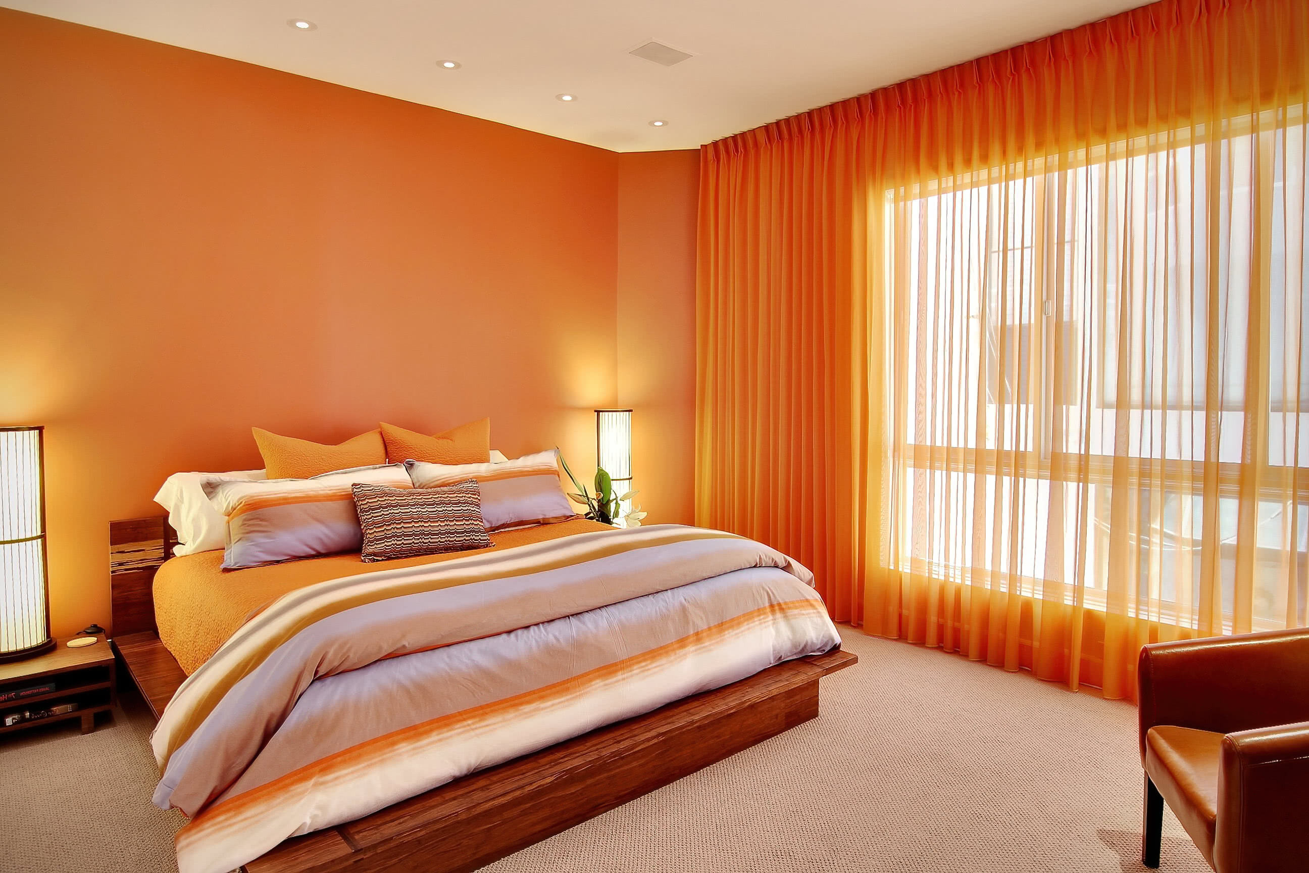Спальня. Оранжевые стены, шторы, покрывало, кресло, кровать